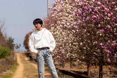 beautiful asian man in the plum woods outdoors