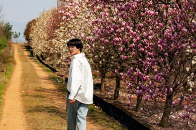 beautiful asian man in the plum woods outdoors
