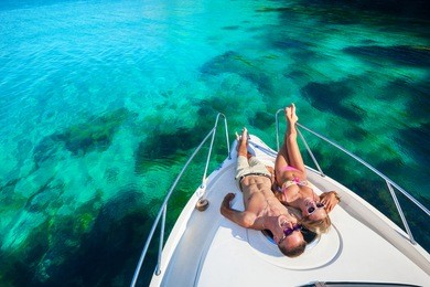 happy couple lying on a boat at sea. luxury vacation on a yacht in the islands.