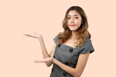 asian woman gesture her hands to the left screen to show something concept on blank copy space, isolated on color background.