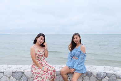 two best friends take pictures together on the beach by the sea. on the weekend