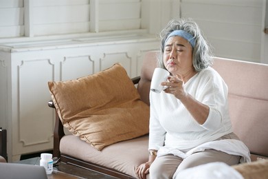 asian senior woman take medicine alone at home