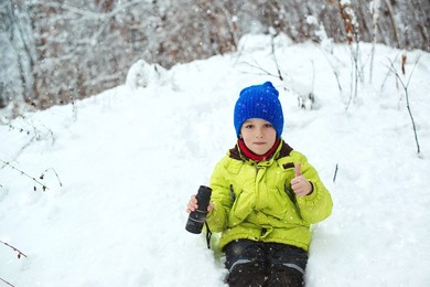 winter fun at nature. cute child explorer in snowy forest. family vacation, snowy day and happy childhood. happy child walking at winter forest. kid looking to monocular. family winter holidays.