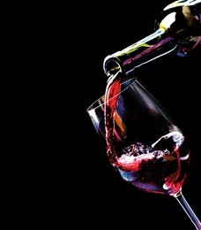 wine. red wine pouring into a wine glass. isolated on black background. border art design