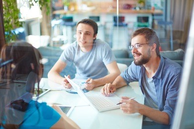 young business partners sharing and discussing ideas at meeting in office