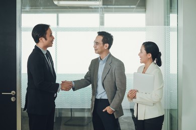 asian businessman handshake making agreement business with professional businessman. behind success is having a good secretary. success deal connection business concept.