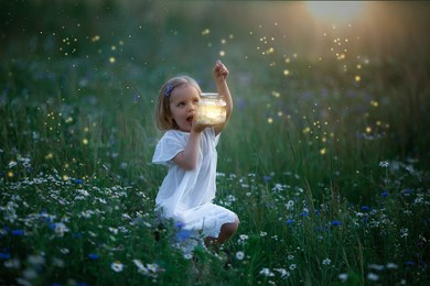 little white girl sits in an evening glade with fireflies