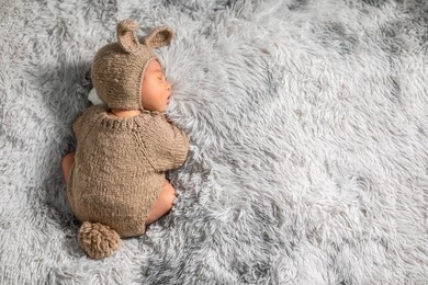 back view happy newborn baby weaing cute rabbit costume lying sleep on grey carpet background comfortable with copy space.cute asian infant sleeping napping on baby bed.newborn baby easter day concept
