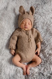 happy newborn baby weaing cute rabbit costume lying sleep on grey carpet background comfortable and safety.cute asian infant sleeping and napping on baby bed.newborn baby easter day concept