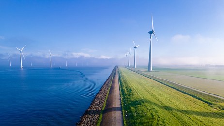 offshore windmill park with clouds and a blue sky, windmill park in the ocean aerial view with wind turbine flevoland netherlands ijsselmeer. green energy 