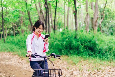 a woman using her phone while riding a bicycle