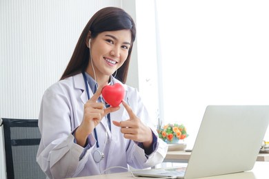 beautiful asian doctor have a bright smile working in the examination room hold a pink heart-shaped ball. cardiac treatment concepts, medical services in hospitals