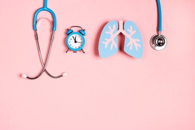 prevention of pulmonary disease. lung symbol, stethoscope and alarm clock on a pink background. healthcare and medicine concept. 