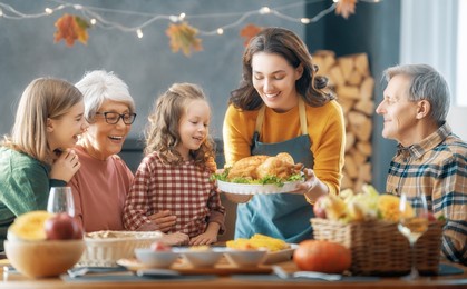 thanksgiving day, autumn feast. happy family sitting at the table and celebrating holiday. grandparents, mother and children. traditional dinner.