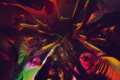 clinking glasses. night lifestyle. group of young, active people at the night club, party dancing in neon, drinking cocktails. concept of party, fun, holiday, relaxation, meeting copy space for ad