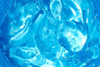 cosmetic gel or beauty jelly serum texture background. blue transparent skin care collagen product backdrop. antibacterial sanitizer or liquid water moisture toner smudged smear close up photo.