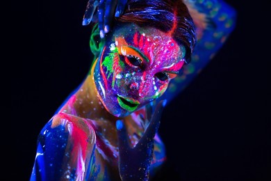 fashion model woman in neon light, portrait of beautiful model girl with fluorescent make-up, body art design of female disco dancer posing in uv, painted face, colorful make up, over black background