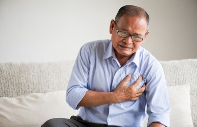 close up senior male asian suffering from bad pain in his chest heart attack at home. healthcare and medical concept of senior heart disease.