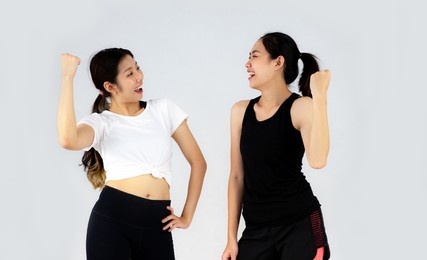 two young asian sport girl posing on the white background.