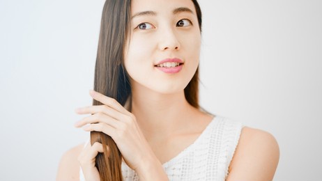 image of a young woman taking care of her hair.