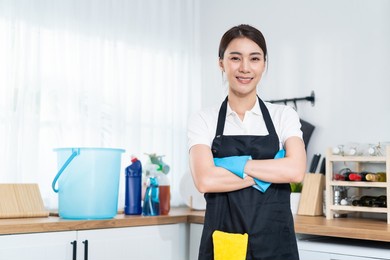 portrait of asian young cleaning service woman worker working in house. beautiful girl housewife housekeeper cleaner crossing arm and smile, looking at camera after doing housework or chores at home.