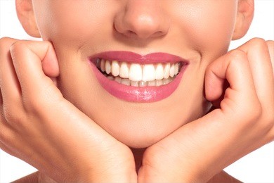 closeup of smiling woman with perfect white teeth on white