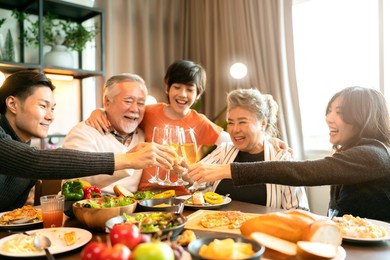 asian multi generation grandparent grandchild happiness joyful dinner together at home,holidays, celebration and people concept - happy friends with sparklers having christmas thanksgiving dinner 