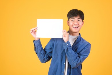 male asian hand is holding blank paper board on white background