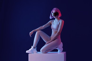 woman in futuristic costume. female in modern vr glasses interacting with network while having virtual reality experience. augmented reality game, future technology, ai concept. vr. neon blue light.