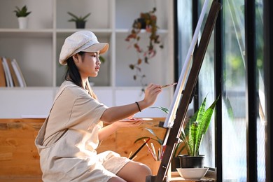 asian girl painting picture with water color in art class.