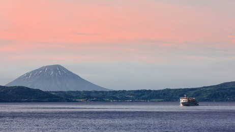 cruising at lake toya with mt. yotei in background, hokkaido, japan