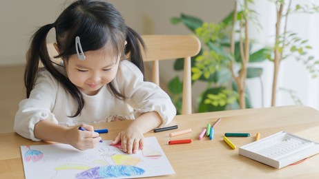 asian child drawing pictures at home