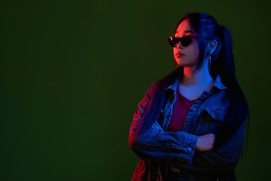 neon fashion. urban style. hipster eyewear. vaporwave trend. cool young woman in multicolor red blue light isolated on black copy space background.