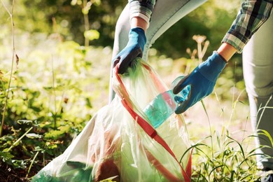 cleanup volunteer collecting trash in the forest and holding a garbage bag, environmental protection concept