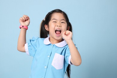the asian girl weraing the school uniform standing on the blue background.