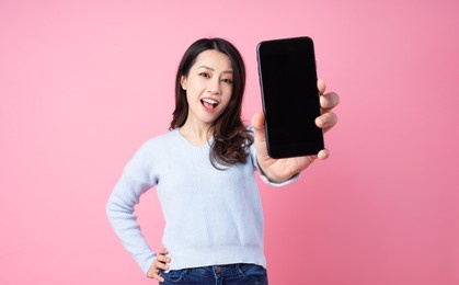 portrait of a beautiful young asian girl, isolated on pink background
