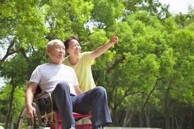 asian senior man sitting on a wheelchair with his wife
