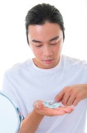 asian man applying shaving foam on his hands preparing to shave. isolated on white background