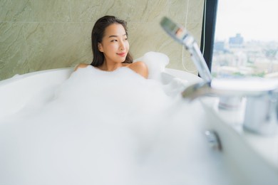 portrait beautiful young asian woman relax and leisure in bathtub decoration in bathroom interior