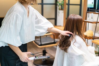 hair stylist using a hair iron