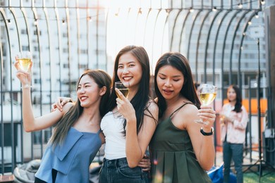 group of happy asian girl friends celebrating party with champagne glasses in sunset together, female gang chatting, laughing on smile face, night lifestyle of young people