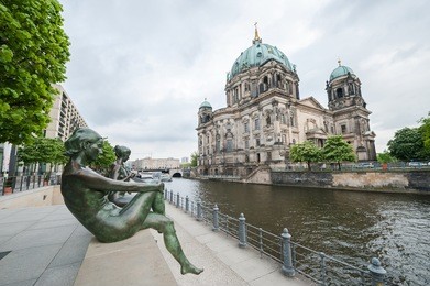 statues along the spree river bank opposite the berlin cathedral