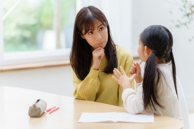 young asian woman studying with mother