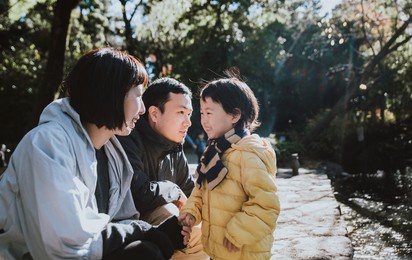 happy japanese family spending time outdoor at the park. mother, father and their kid having fun on the weekend in tokyo. concepts about lifestyle and cultures
