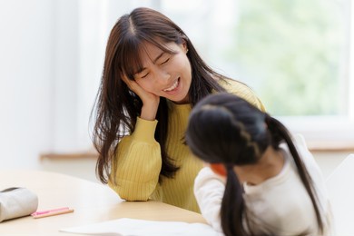 young asian woman studying with mother