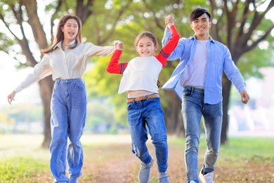 happy family jumping and playing together in the park
