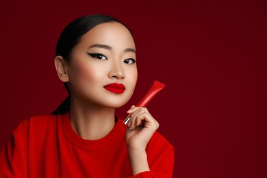 red lipstick. attractive young korean model with red lips make up posing with beauty product