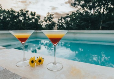 tropical cocktails and yellow flowers  by the roof top pool on a cloudy day in the tropical jungle