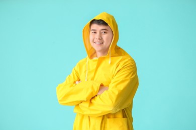 young asian man in raincoat on color background