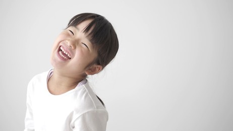 portrait of young asian girl laughing on white background
